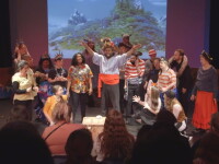 Actors performing on stage in front of an audience. 