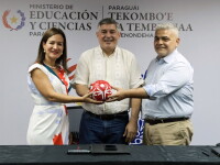 One woman and two men smiling while holding a Special Olympics branded football