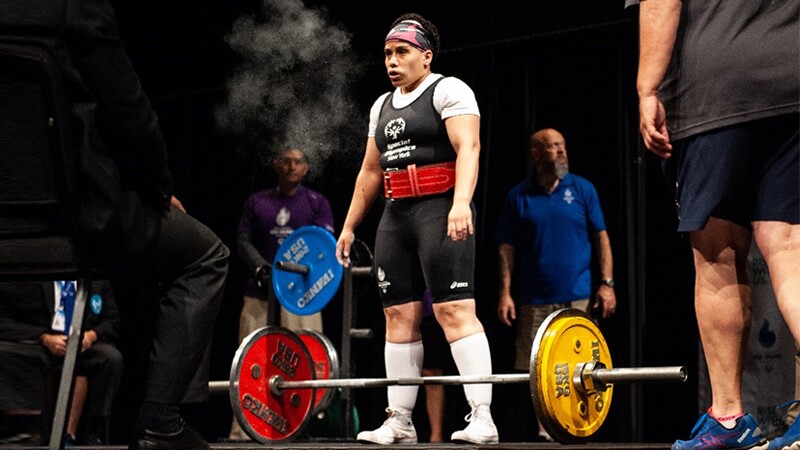 Angel preparing to dead lift; she's standing on stage.