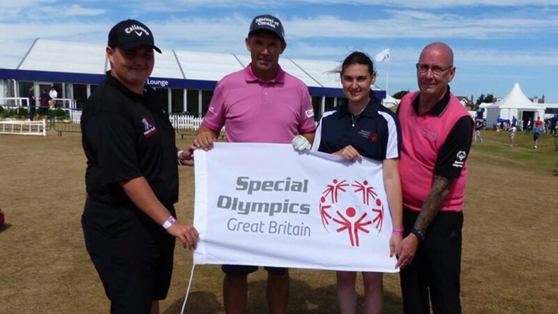 Four people standing out together holding a banner that reads: Special Olympics Great Britain.