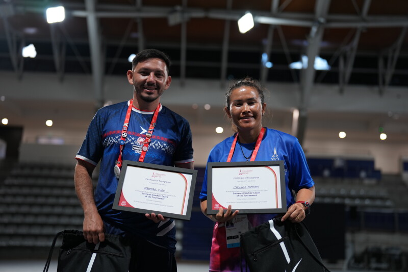 A man and woman standing side by side holding up a certificate. 