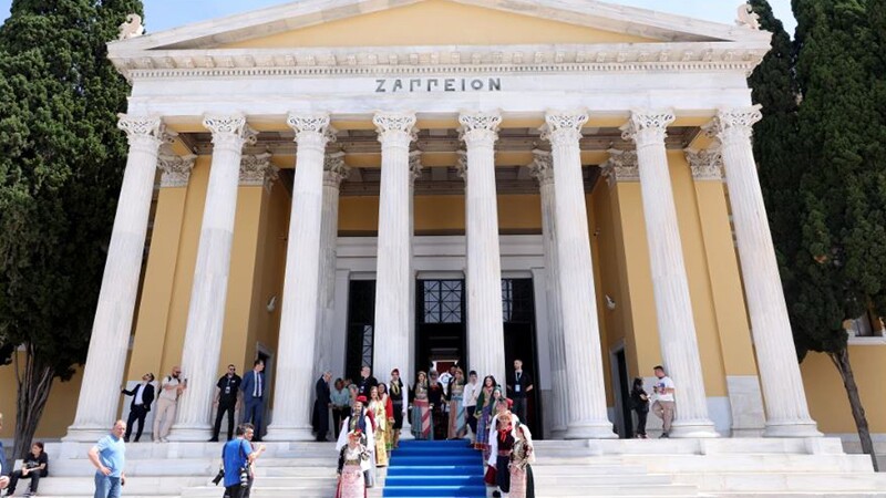 People standing on the stairs in front of a building. 