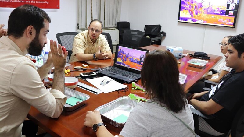 Group of people sitting around a table talking. 