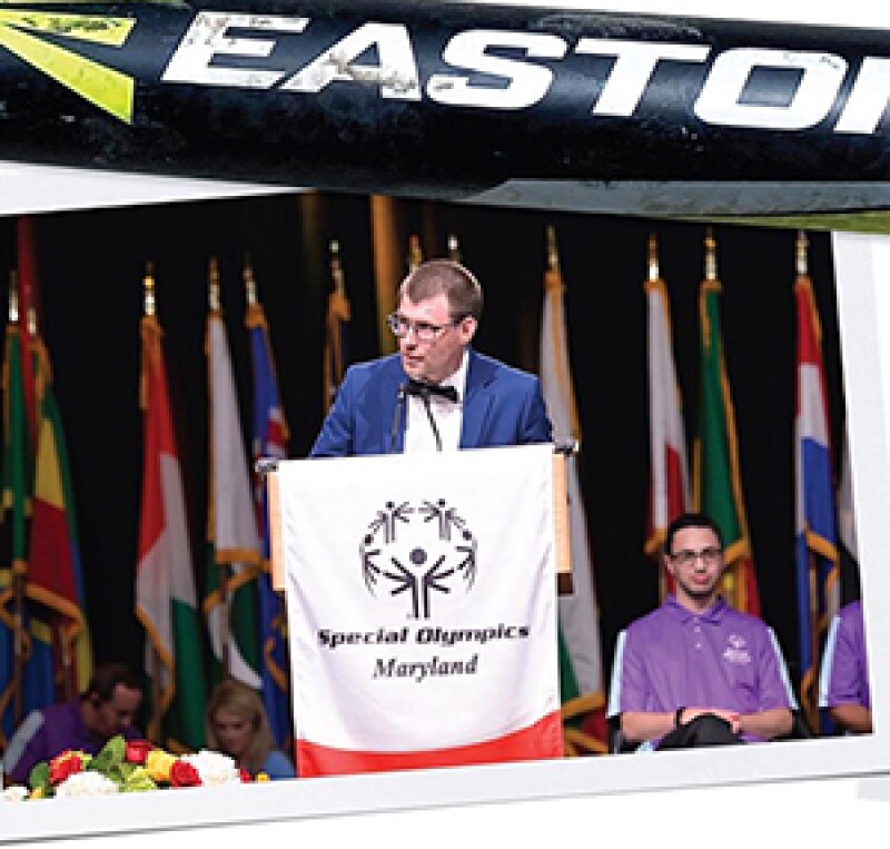 RJ Nealon giving a speech on stage standing behind a podium.