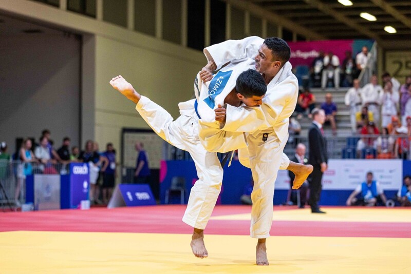 Two competitors in karate uniforms on the mat competing