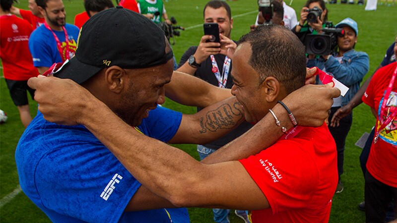 Droba and Cafu on the football field place medals around each others neck at the 2019 world games.