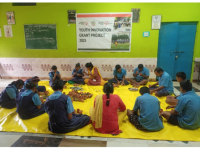 Young people sitting on the floor in a circle. 