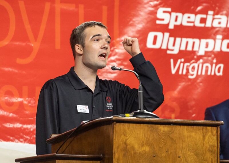 Man standing at a podium with his right fist raised