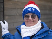 Woman wearing Special Olympics France winter gear poses for the camera and smiles