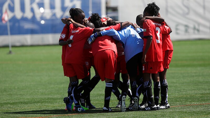 A football team huddled on the field together as a team. 