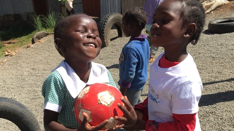 Girls from Special Olympics Kenya play with soccer ball.