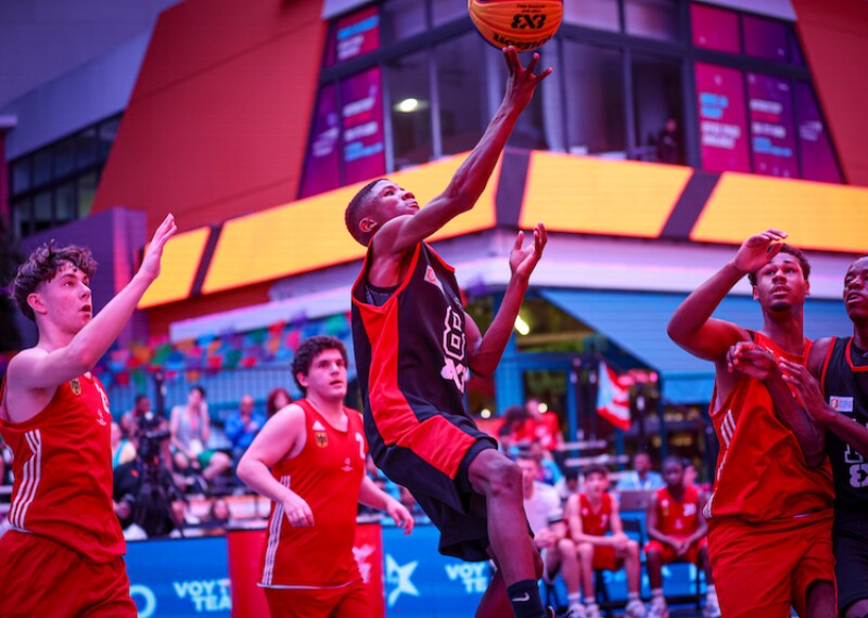 During a game, a player leaps for the ball as his opponents and teammates look up.