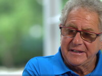 Doctor Richard Perlman sitting for an interview. He has on an blue polo shirt. 