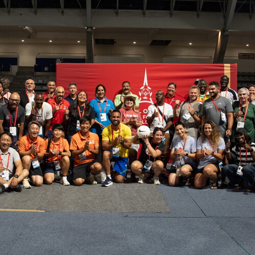 Large group photo in a gymnasium setting, a Special Olympics Unified Football World Cup Paris 2026 banner is behind the group. 