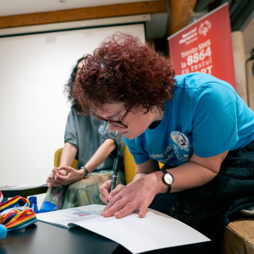 A woman signs an open book. 