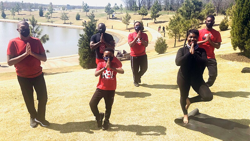Eric and family members practice yoga together.