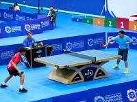 Table tennis players in the midst of a match. 