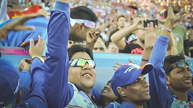 Shrey Kadian puts his fist in the air while in the middle of a crowd.