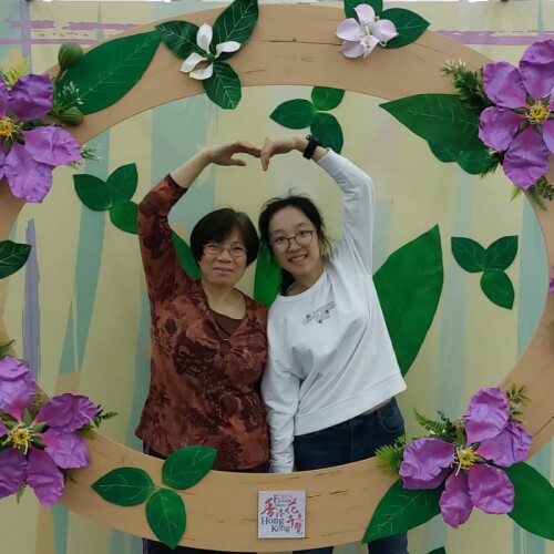 Lai Man Yee and her mother, Chan posing with their arms overhead to make a connecting heart shape