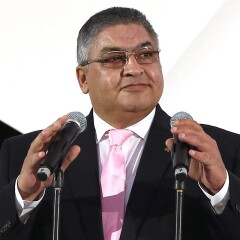 Ayman Abdel Wahab behind a podium with two microphones.
