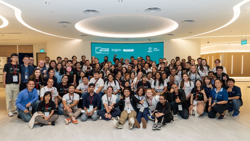 A large group of people in multiple rows, kneeling, squatting, and standing for a group photo. 