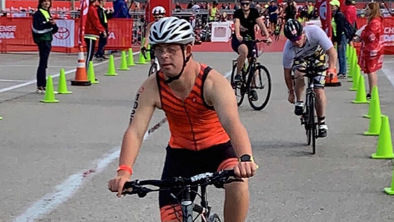 Chris Nikic biking at a competition.