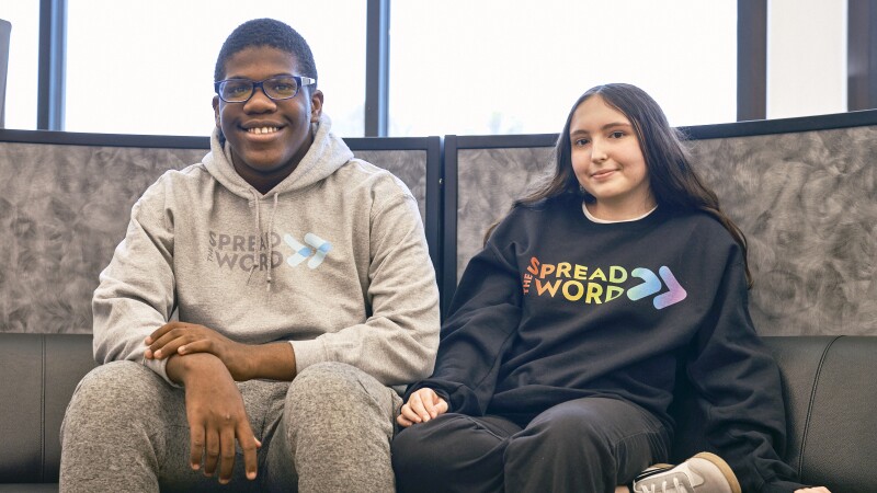 Two people sitting down and smiling.
