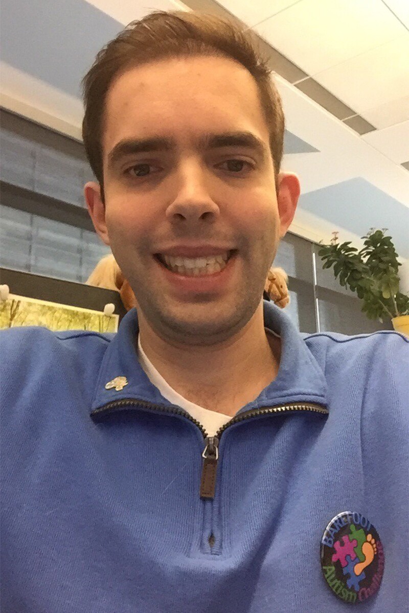 Selfie of Tyler Leech posing with a Barefoot Autism Challenge pin on his chest.