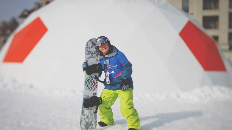 Athlete on the snow holding his board.