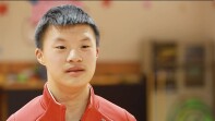 Xiang Li in a red athletic zip up. 