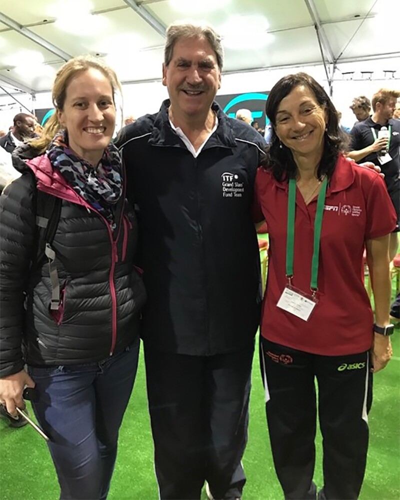 Coach Maria standing with David Hagherty and Fiona Murry in a venue.