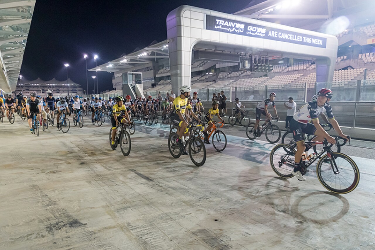 A large group of cyclists start off on their first lap around Yas Marina Circuit.