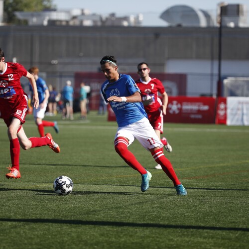 Futbolistas en el campo persiguiendo el balón.