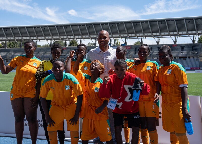 A group of footballers pose for a photo in a football stadium