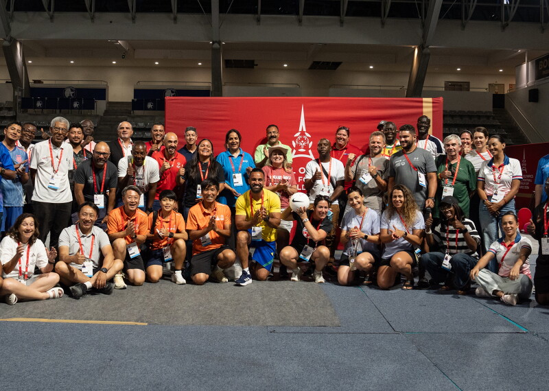 Large group photo in a gymnasium setting, a Special Olympics Unified Football World Cup Paris 2026 banner is behind the group. 