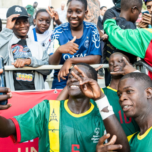 Two Special Olympics Senegal players posing with fans in the Stands