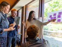 A group of four people working on post it notes stuck to a window