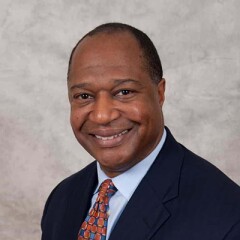 Dale Jones in a blue shirt, suite, and patterned tie.