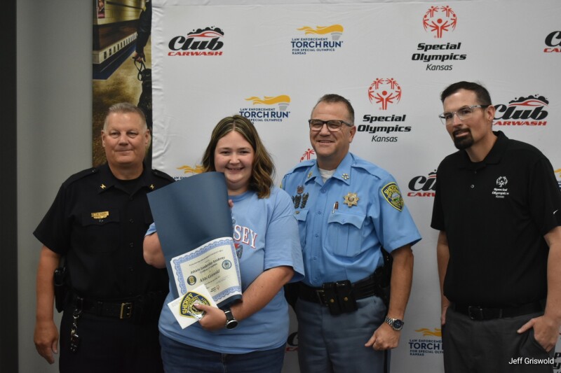 A young woman standing with three men in an official setting. 