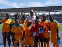 A group of footballers pose for a photo in a football stadium