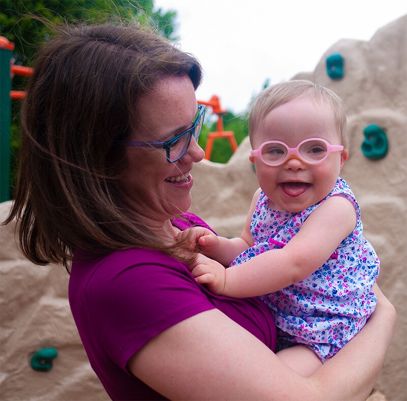 Margot holding Hannah at the playground.