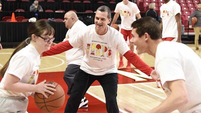 Athletes on the court playing basketball.