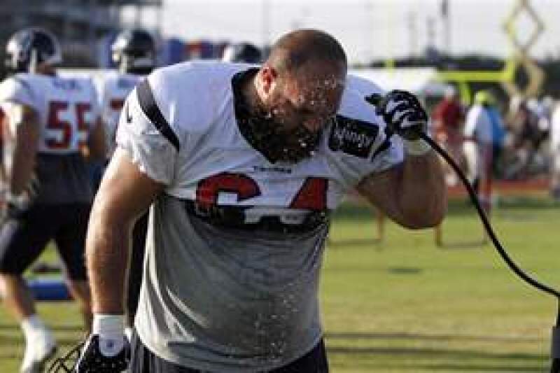 Houston Texans offensive lineman, Kasey Studdard, hoses himself down during a hot practice.