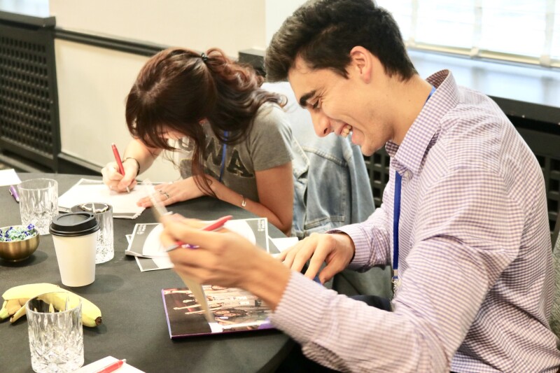 Two participants sitting at a table looking at workbooks