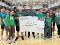 A group of people standing together holding up a banner. 
