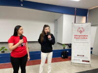 Two youth leaders with microphones standing in front of a stage