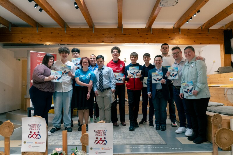 A group of people stand together holding books.