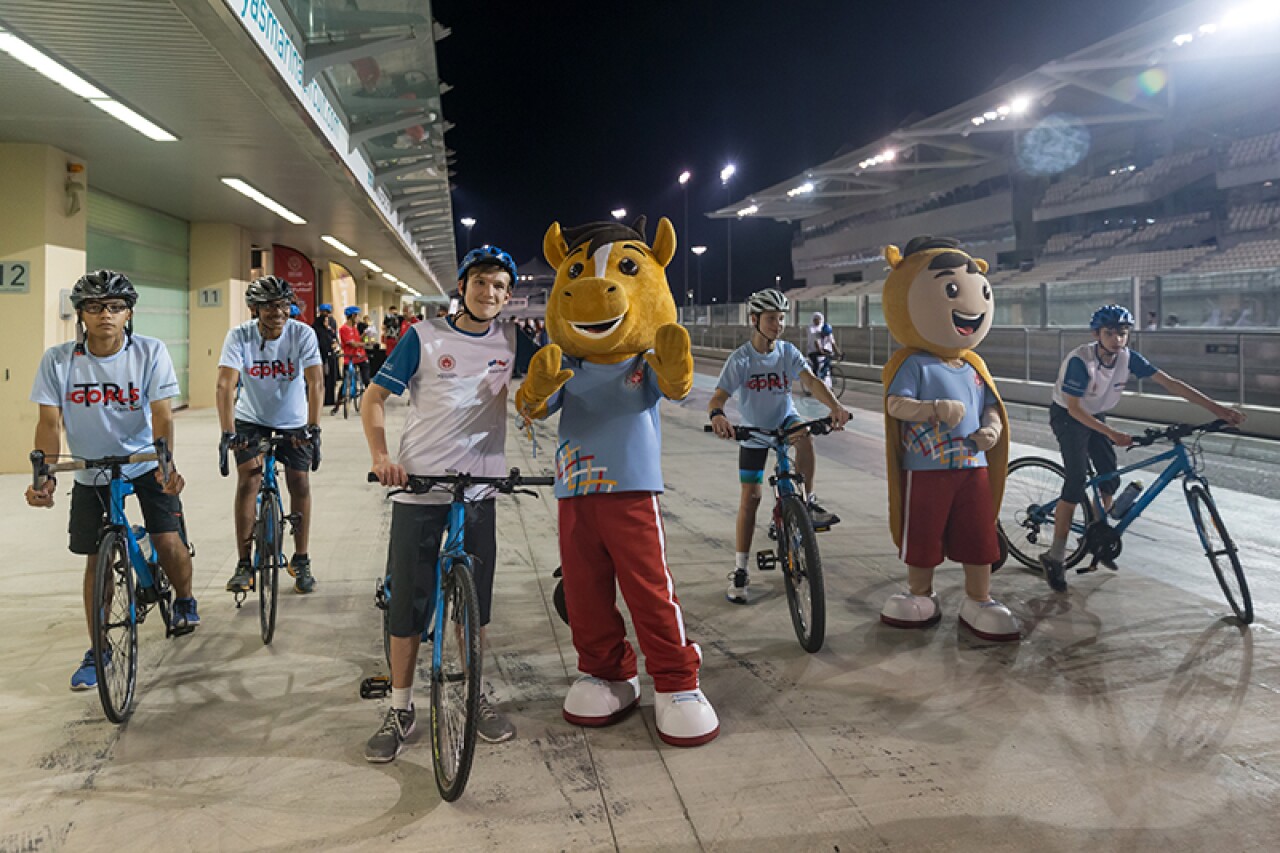 Special Olympics World Games mascots pose with five cyclists.