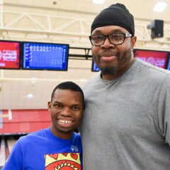 Sam Perkins standing with a young man in a bowling alley