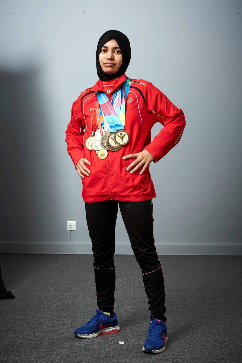 Hamda poses in Special Olympics apparel with many gold medals around her neck.